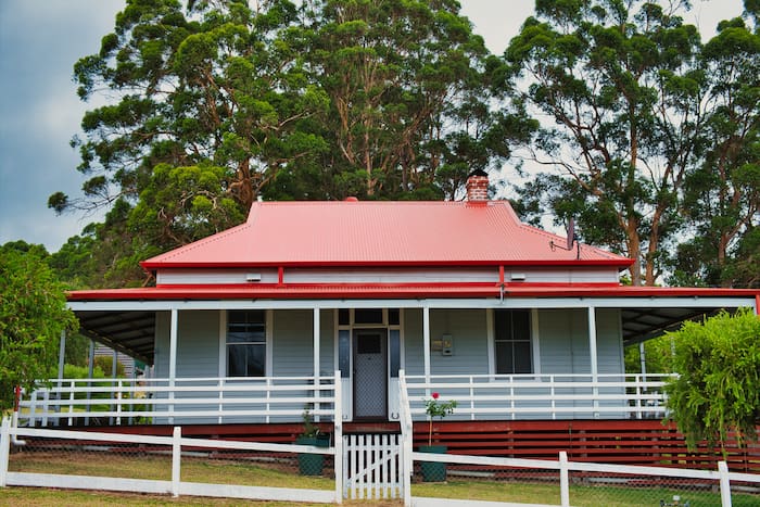 Blue workers cottage with metal roof in suburban Australian street