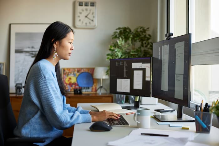 A young woman works on the computer in her at-home office.