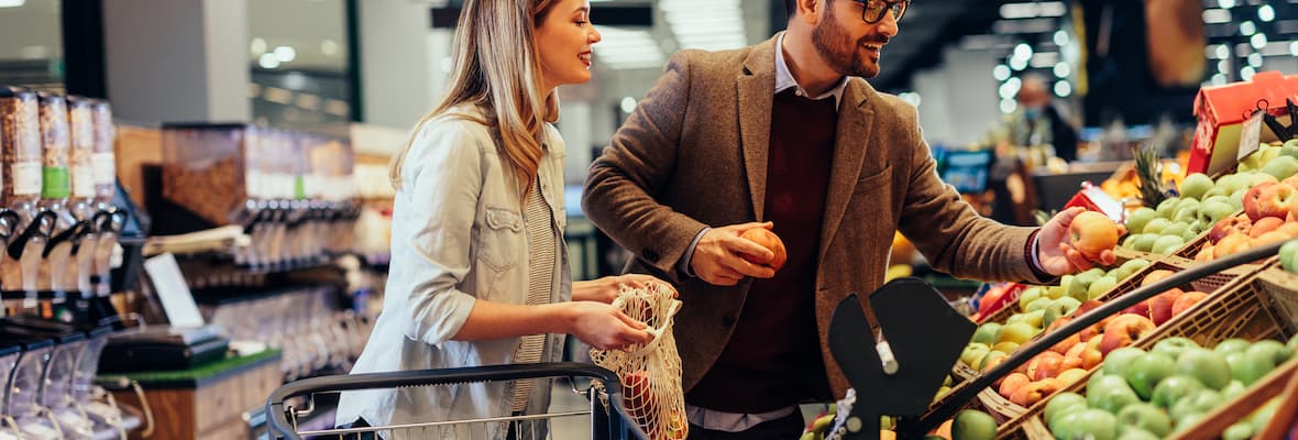 A young couple shops for fruit in the grocery store