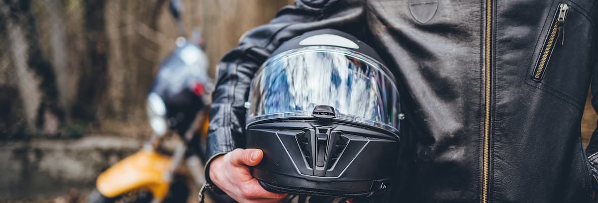 Motorcyclist holds helmet outside