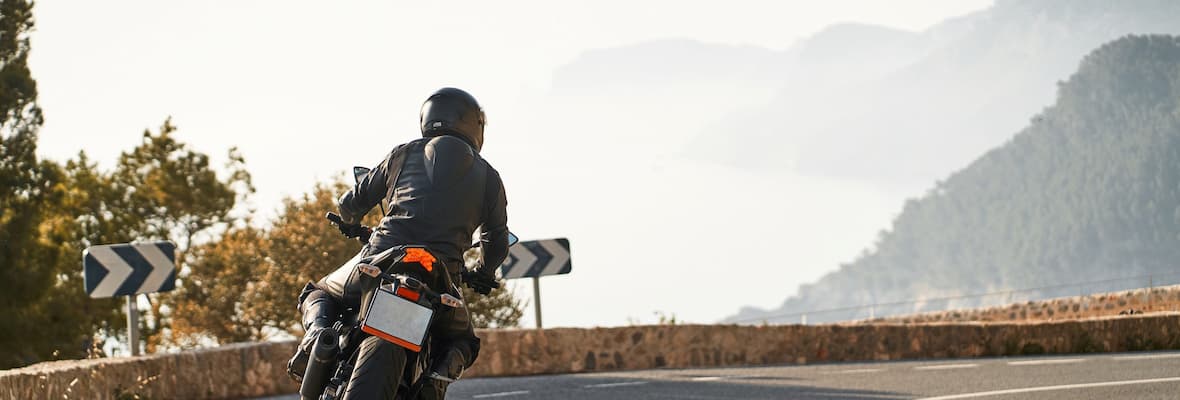 Motorcyclist riding along range drive on mountains