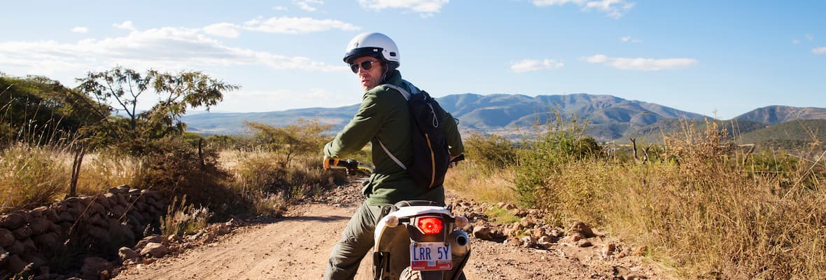 A man riding on his motorbike in the Mexican countryside.