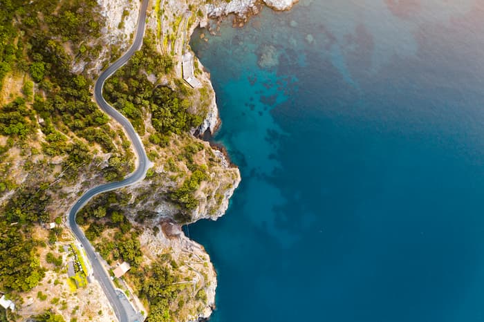 The Amalfi Coast Road winds through shrubbery on the Italian coast.