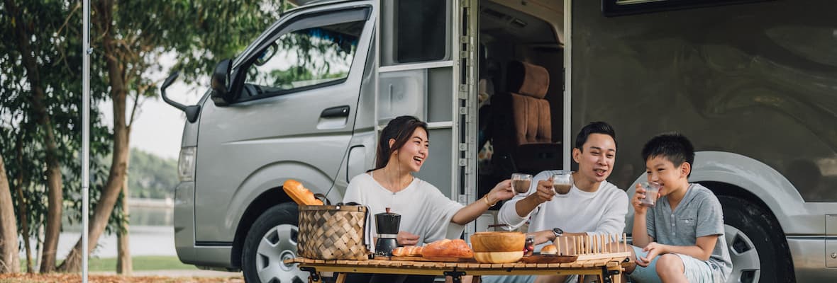 Young family has a picnic outside their caravan