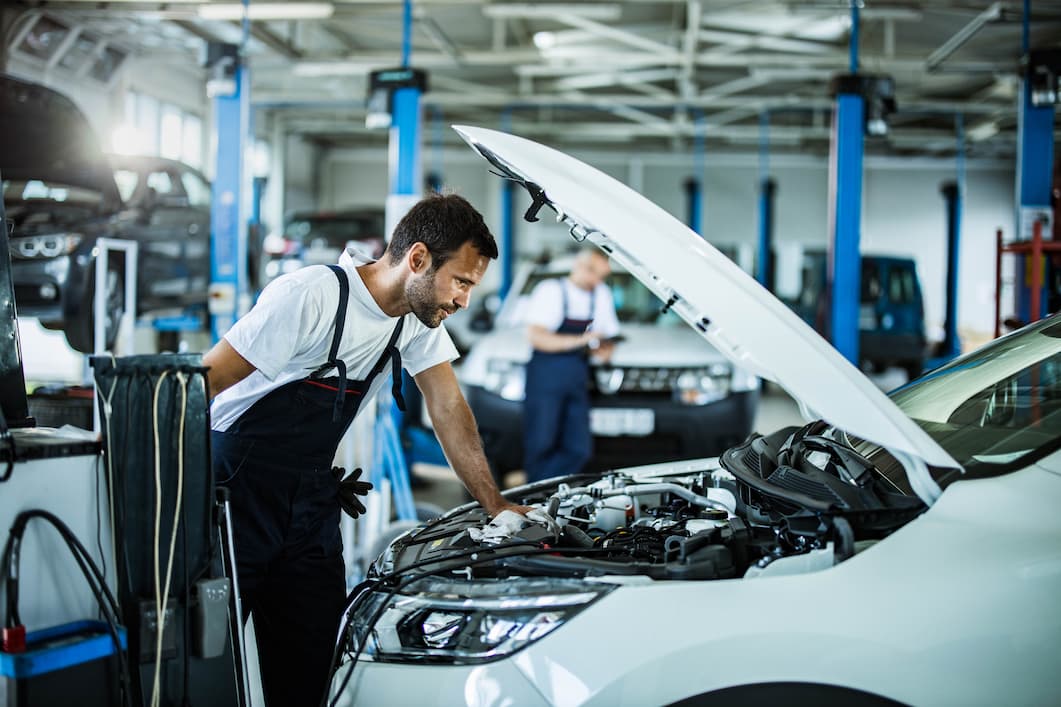 Male mechanic analysing engine problems while working in an auto workshop