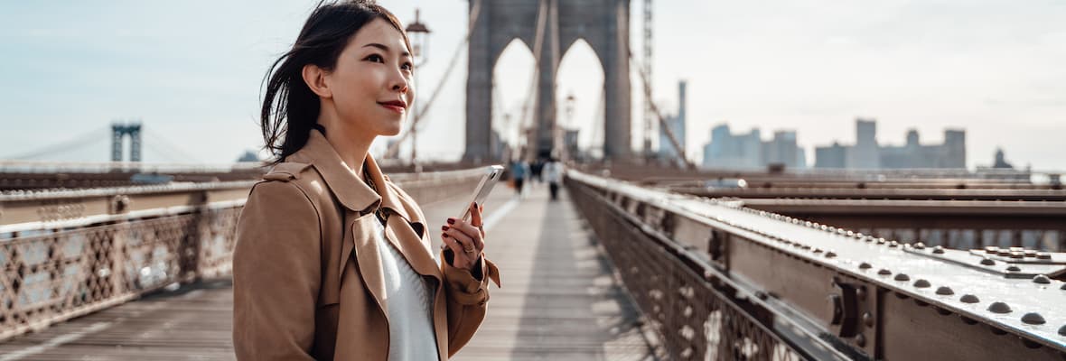 Young woman stands on Brooklyn bridge