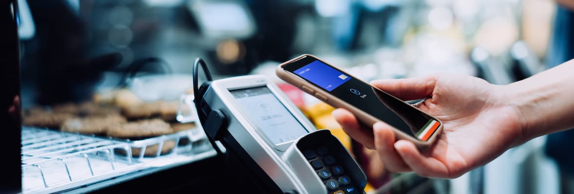 Close up of a woman's hand using her smartphone to pay