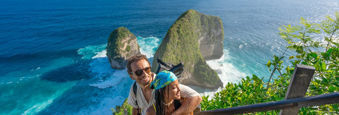 Young couple stands on the stairs above Kelingking beach near Bali.