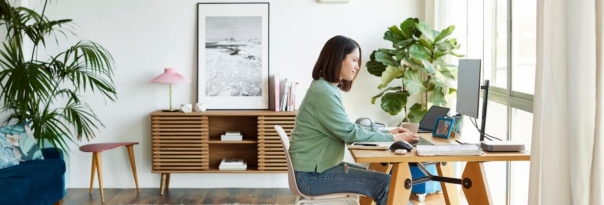 A young woman applies for annual leave on a desktop computer in her home office