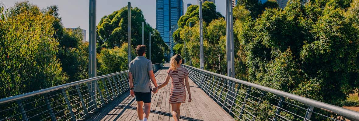 Man and woman walking down bridge into Melbourne city