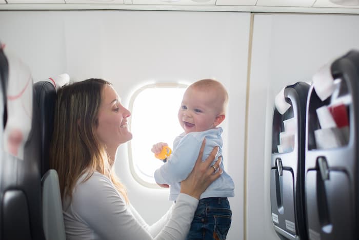 Smiling baby on mother's lap on flight