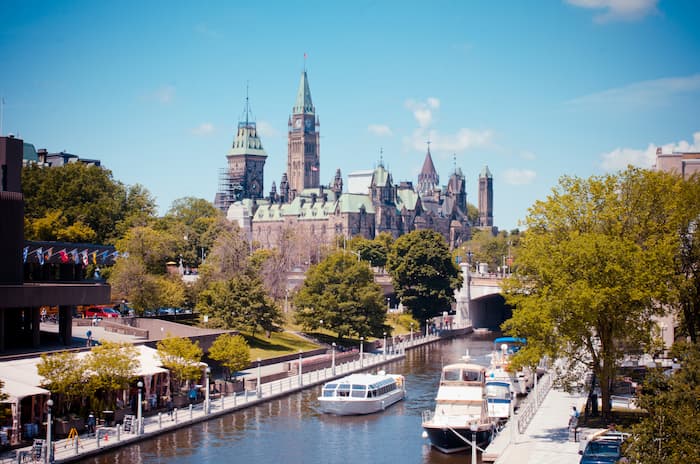 Ontario's city centre is surrounded by heritage buildings, restaurants and boats along a river.