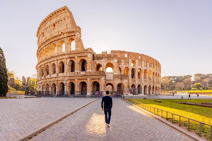 man walking towards coliseum in Rome italy